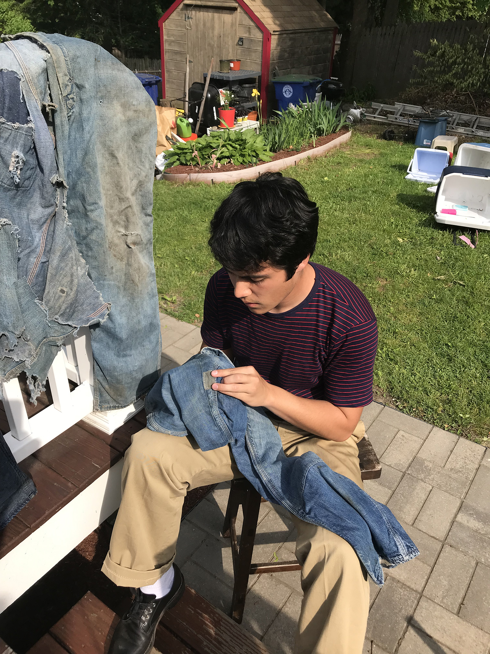 Ben Keefe sits down as he repairs jeans