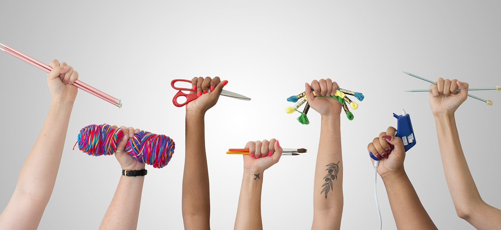 7 raised hands holding crafting gear